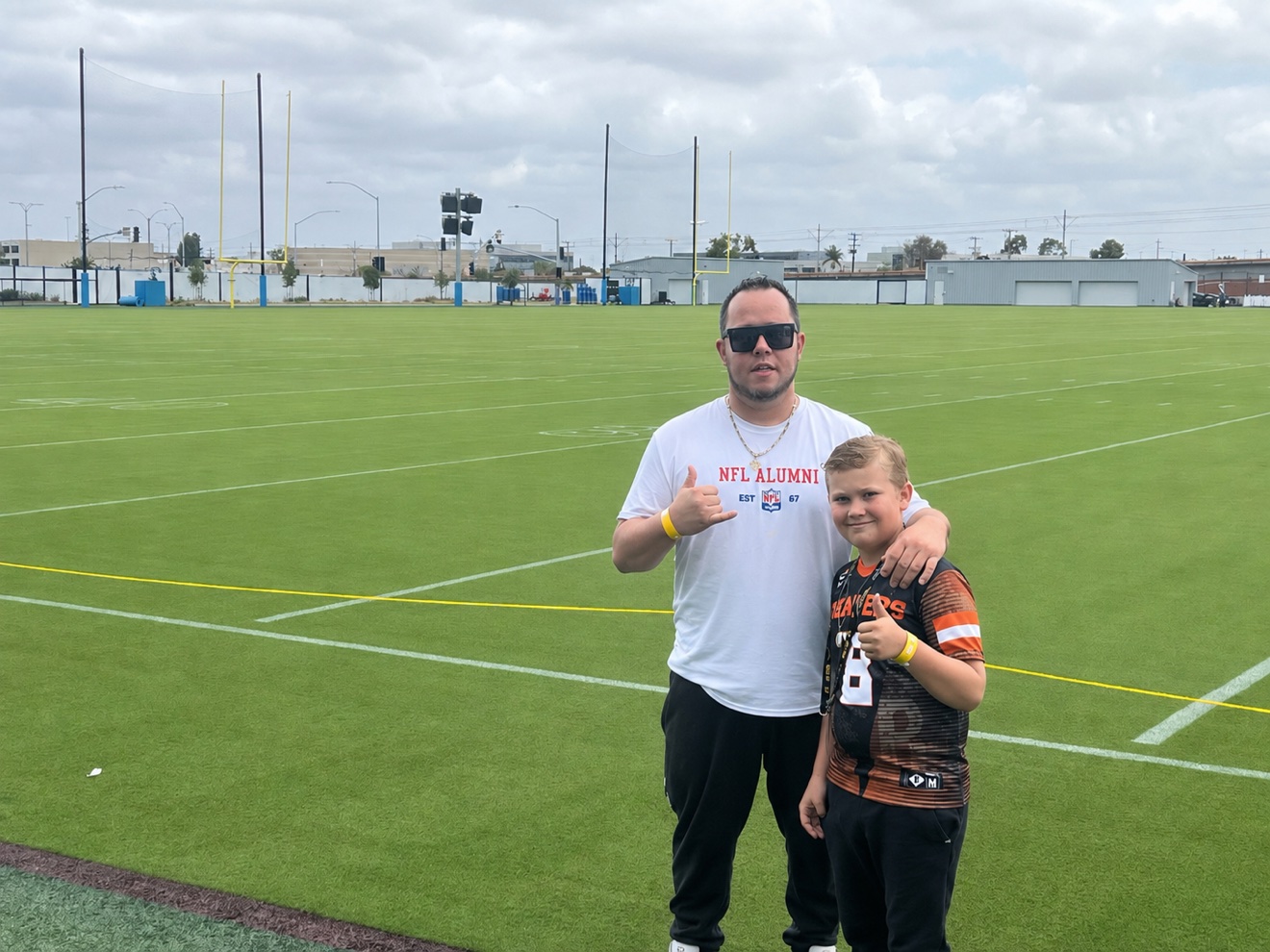 Emad Alayoubi in an NFL Alumni shirt on the field